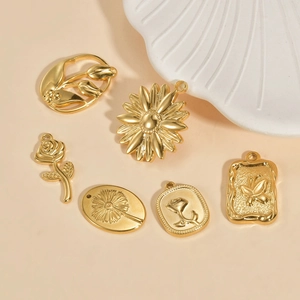 Detailed view of various golden DIY jewelry pendants featuring floral and butterfly motifs