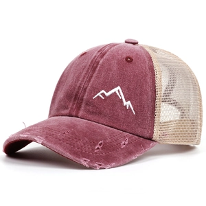 Close-up of vintage mountains embroidery on a distressed maroon and beige trucker hat