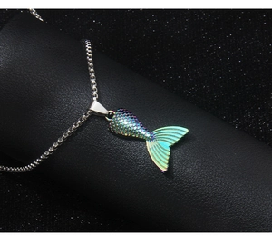 Detail shot of the iridescent fishtail pendant showing blue and purple gradient tones