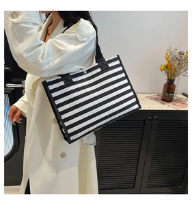 Borsa tote minimalista a righe bianche e nere con manici rinforzati e dettagli di borchie