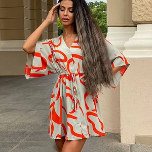 Détail d'une robe imprimée à col en V avec ceinture à nouer et motifs abstraits