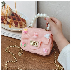 Detail of pink silicone girls' purse featuring pearl handle, chain, and cute charms