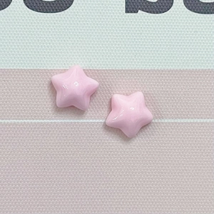 Close-up of two glossy pink macaron-style resin stars for DIY jewelry and phone cases