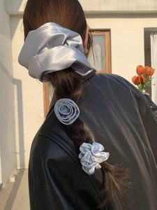 Satin silver grey rose hair clip and scrunchie set styled on a braided ponytail