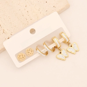 Detailed close-up of gold butterfly and flower earring set with sparkling rhinestones