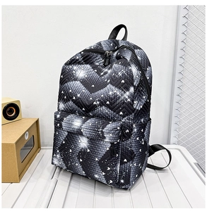Detalle de la mochila negra con diseño de rombos y estampados de estrellas y corazones