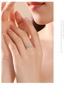 Close-up of a silver V-shaped ring with a sparkling cubic zirconia stone worn on a finger