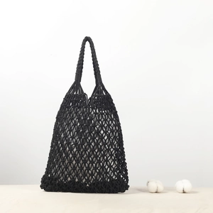 Detailed view of black woven cotton rope handbag with intricate mesh hollowed-out pattern