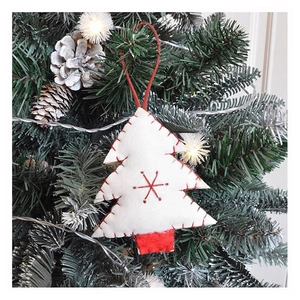 Detailed view of white felt Christmas tree ornament with red embroidery and hanging rope