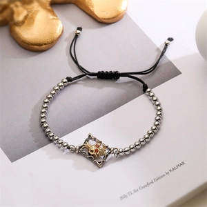Detail of adjustable evil eye bracelet featuring golden skull and red zircon accents