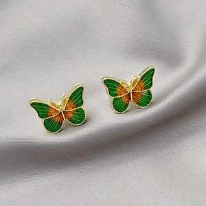 Detail of green and orange gradient enamel butterfly earrings with gold plating edges