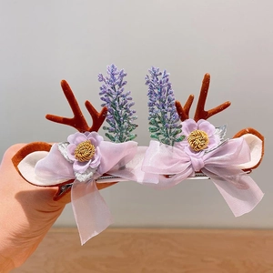 Detailed close-up of Christmas reindeer antler hair clip with purple flowers and bows