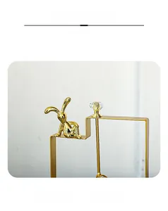 Macro view of gold iron rabbit napkin holder with geometric frame and crystal detail