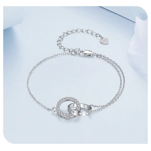 Macro detail of S925 sterling silver double-ring bracelet with heart cutout and crystals