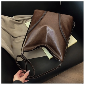 Detail of vintage brown PU leather shoulder bag with glossy texture and large capacity