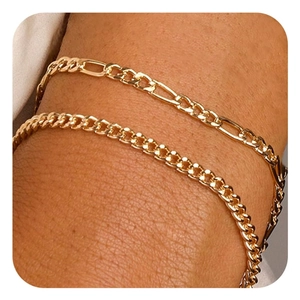 Nahaufnahme des geschichteten vergoldeten Messing-Figaro- und Curb-Armband-Sets für Damen
