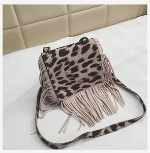 Detail view of children's leopard print crossbody bag with long beige fringe and metal buckle