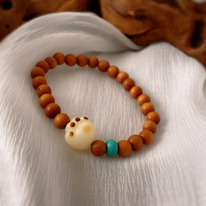 Vintage sandalwood beaded bracelet featuring white acrylic cat paw and turquoise accents