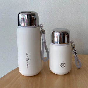 Close-up of matte white stainless steel insulated cups with premium silver lids and straps