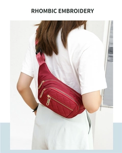 Detailed view of wine red fanny pack featuring rhombic embroidery and gold zippers