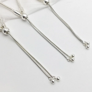 Detail of silver snake chain bracelet featuring adjustable round slider clasp closure