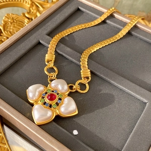 Detail van vintage gouden bloemenketting met parels en robijnen in luxe doosje