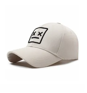 Close-up of beige baseball cap featuring a minimalist embroidered face patch and twill texture
