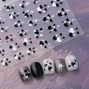 Detail of heart and star nail stickers on gray wood background showing application effect