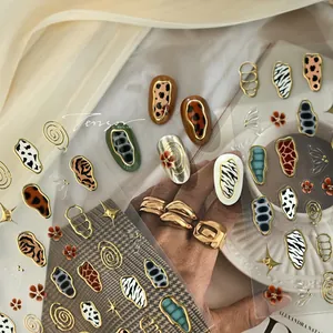 Detail of French animal print nail stickers featuring leopard and zebra patterns with gold lines