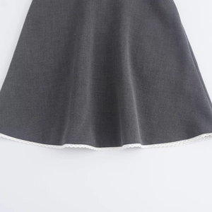 Detailed close-up of gray dress hem featuring delicate white lace trim and cotton texture