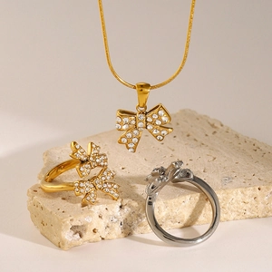 Elegant bow-shaped jewelry set with necklace and rings featuring sparkling rhinestones