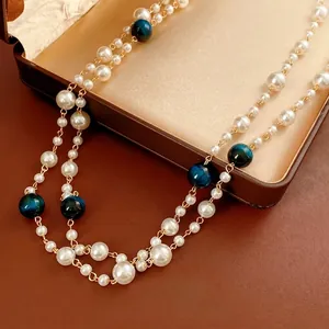 Luxury double-layered necklace featuring white pearls and deep blue tiger eye beads