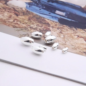 Macro shot of silver olive-shaped oval beads for DIY jewelry in multiple sizes