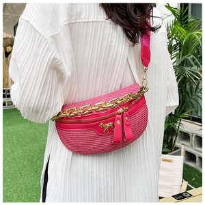 Détail du sac ceinture tissé fuchsia avec emblème de cheval doré et chaîne chic