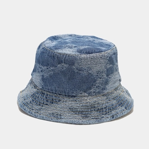 Detailed view of mid-blue washed denim fabric texture and stitching on a bucket hat