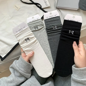 Detail view of cotton crew socks featuring delicate bow embroidery and ribbed cuffs