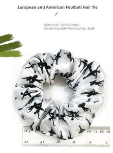 Detail of white satin scrunchie featuring black ballerina silhouettes and scale reference