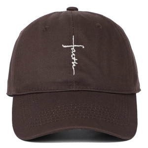 Close-up of white faith cross embroidery on deep brown cotton twill baseball cap