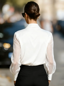 Detail of white satin shirt featuring semi-transparent vertical stripe patchwork sleeves
