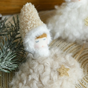 Plush angel doll ornament with gold star and wool texture in a festive Nordic setting