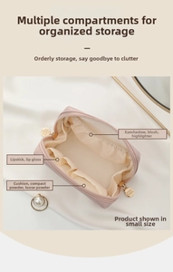 Interior detail of pink small cosmetic bag showing elastic compartments and dividers