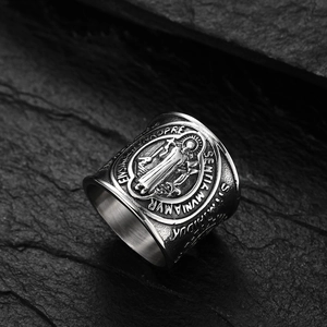 Macro detail of retro St. Benedict medal ring with vintage relief on dark stone
