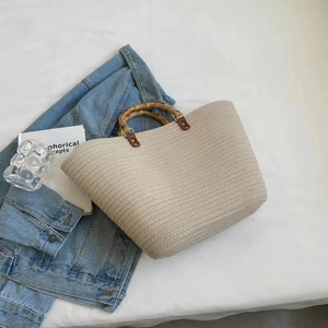Chic woven tote bag with bamboo handles and large capacity, stylish straw beach bag design