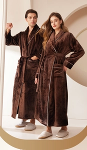 Close-up of thick brown coral fleece robes with white trim details and soft plush texture