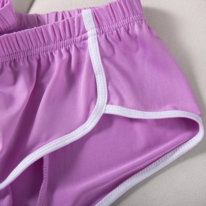 Detailansicht der lila Yoga-Shorts mit weißen Paspeln und elastischer Bundstruktur