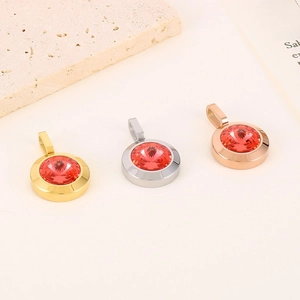 Detailed view of three polished stainless steel necklaces with red round crystal pendants
