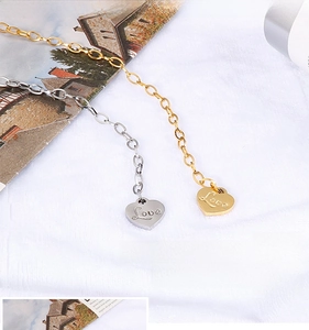 Macro view of gold and silver heart pendants with Love engraving on a white background