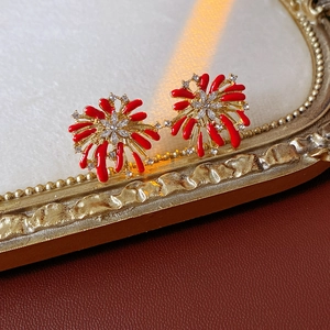Detailed view of red coral-style earrings with gold base and embedded diamonds