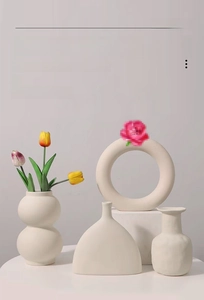 Minimalist matte white unglazed ceramic vases in various geometric shapes for home decor