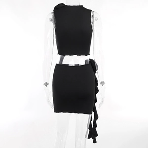 Detailed view of black sleeveless crop top and ruffled mini skirt set on transparent mannequin